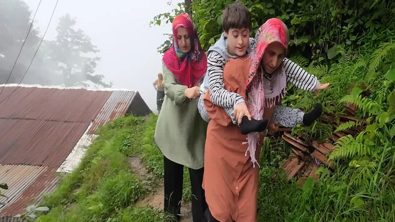 Yağmur çamur demeden Down sendromlu kızı Zümra’yı sırtında taşıyan anne, bölgeye yol yapılmasını istiyor
